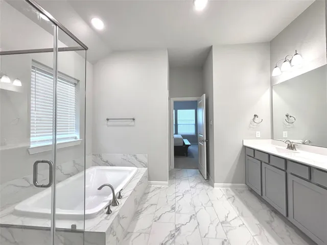 a bathroom with a tub sink and mirror