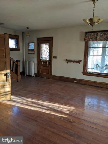 a view of a livingroom with wooden floor and windows