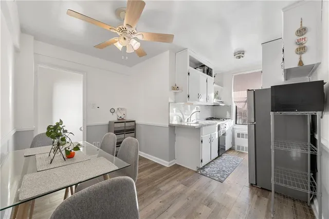 a kitchen with kitchen island stainless steel appliances a stove refrigerator dining table and chairs