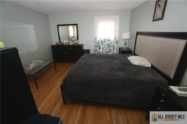 a bedroom with a bed window and dresser