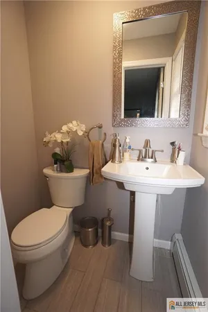 a bathroom with a toilet a sink and mirror