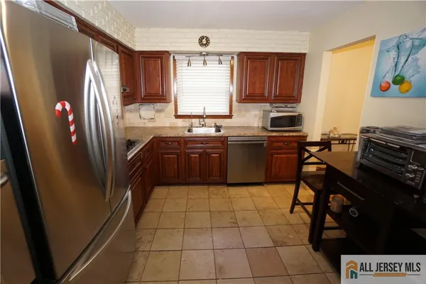 a kitchen with stainless steel appliances granite countertop a refrigerator and a stove