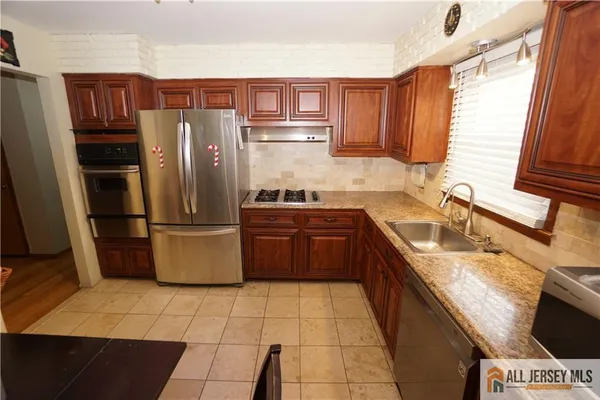 a kitchen with stainless steel appliances granite countertop a refrigerator sink and stove