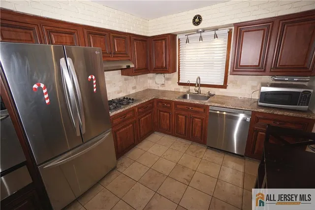 a kitchen with stainless steel appliances granite countertop a refrigerator sink and cabinets