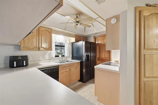 a kitchen with stainless steel appliances granite countertop a refrigerator a sink dishwasher a stove and a refrigerator with wooden floor