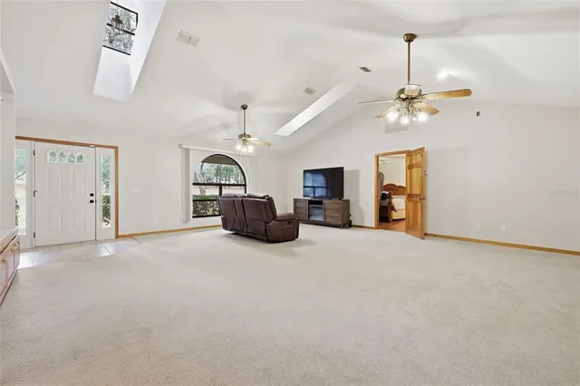 a view of a livingroom with a chandelier furniture and a ceiling fan