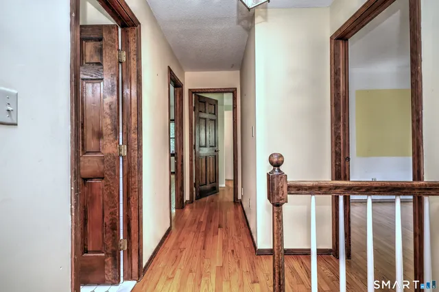 a view of a hallway with wooden floor and staircase