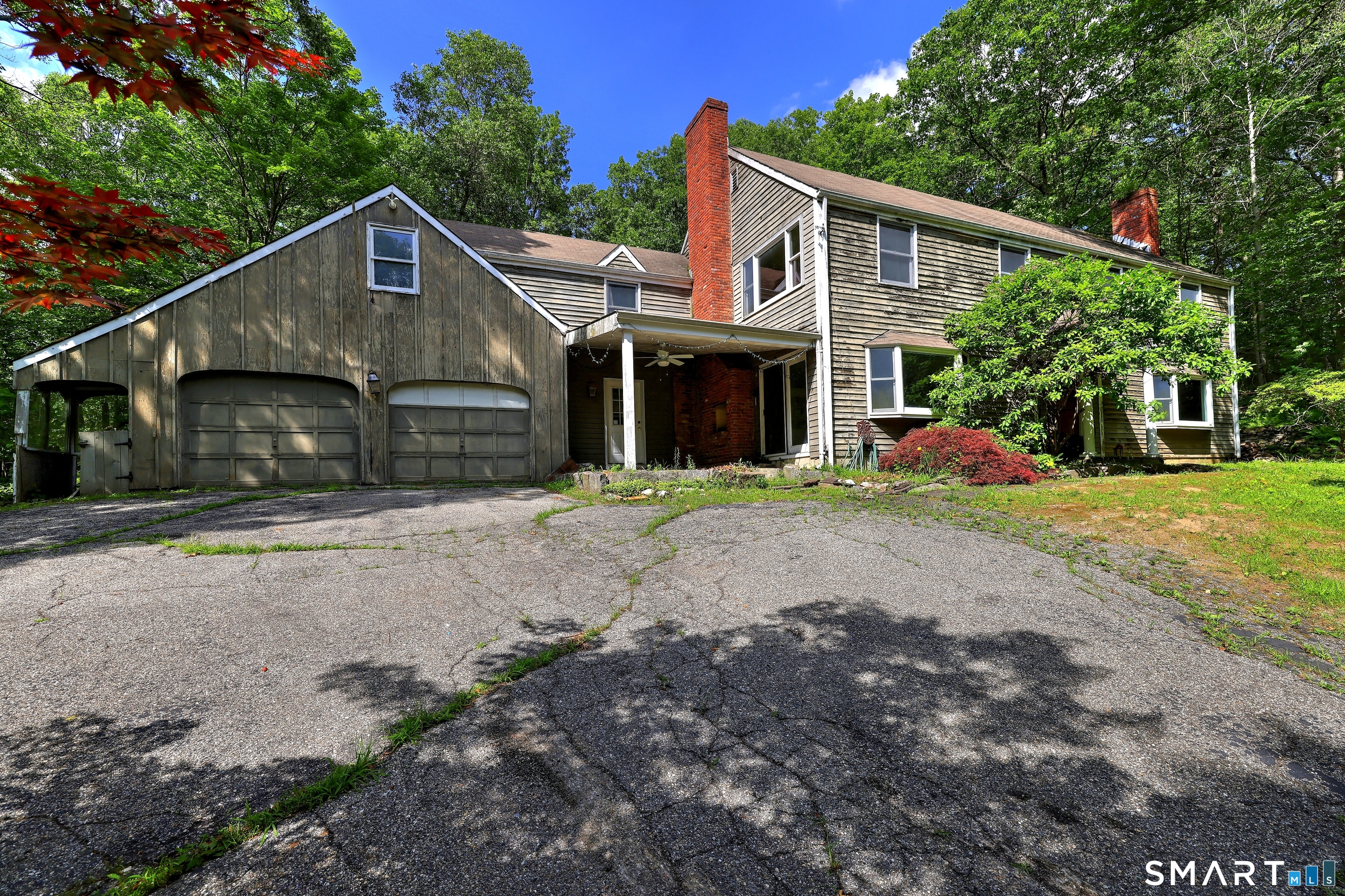 22 East Woods Road Roxbury, CT 06783 - Photo 2 of 37 a front view of a house with a yard and garage