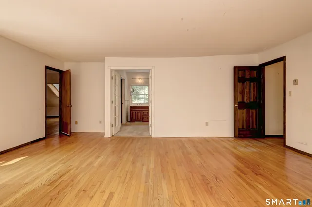 a view of an empty room with closet and a window