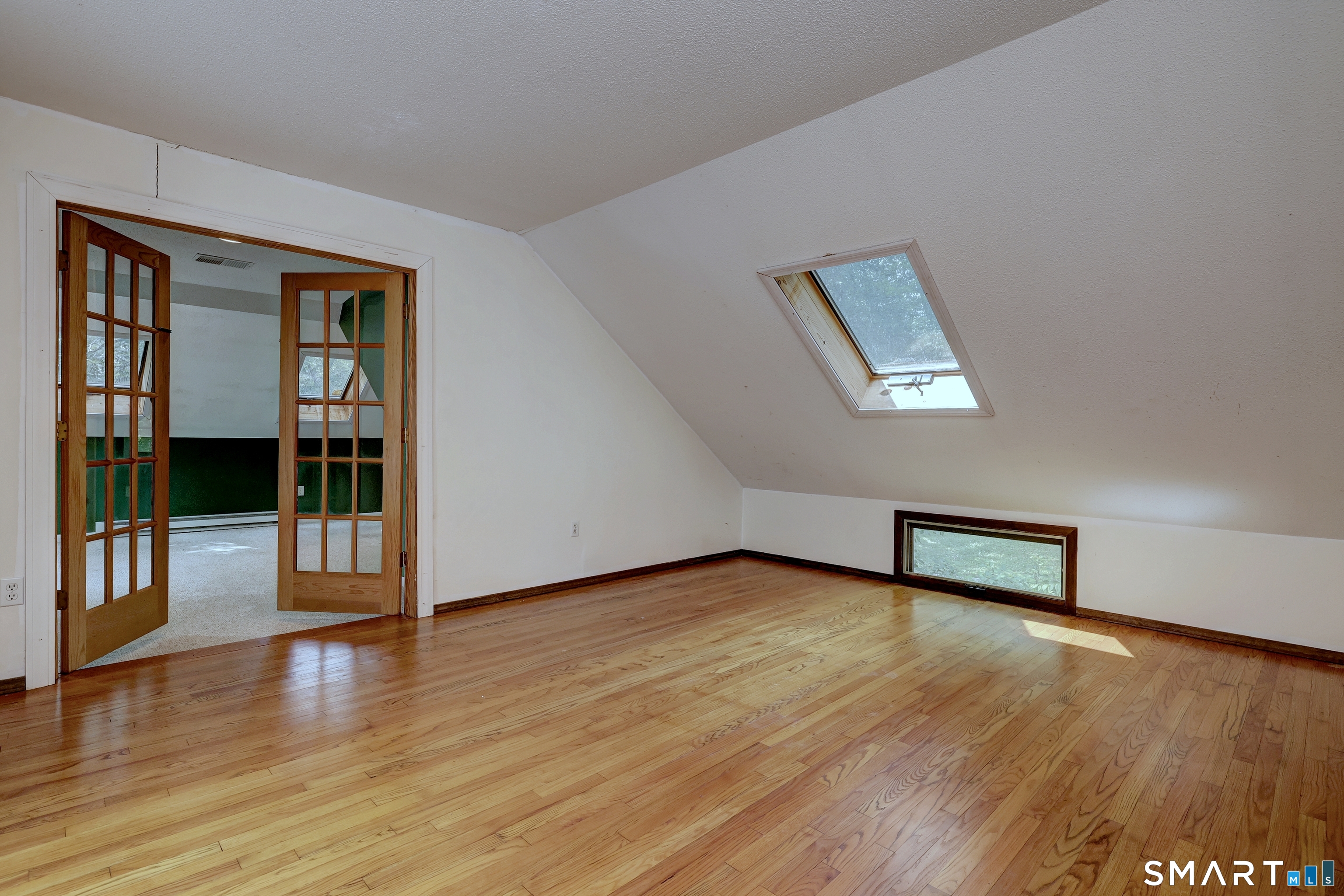 22 East Woods Road Roxbury, CT 06783 - Photo 22 of 37 a view of an empty room with wooden floor and a window