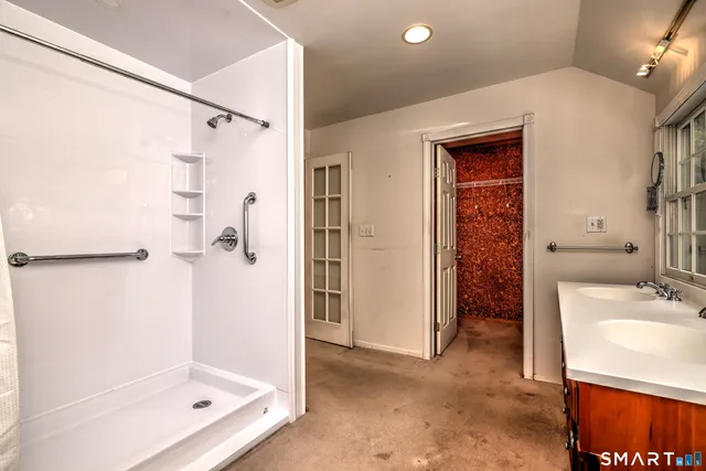 a bathroom with a tub sink shower and a mirror