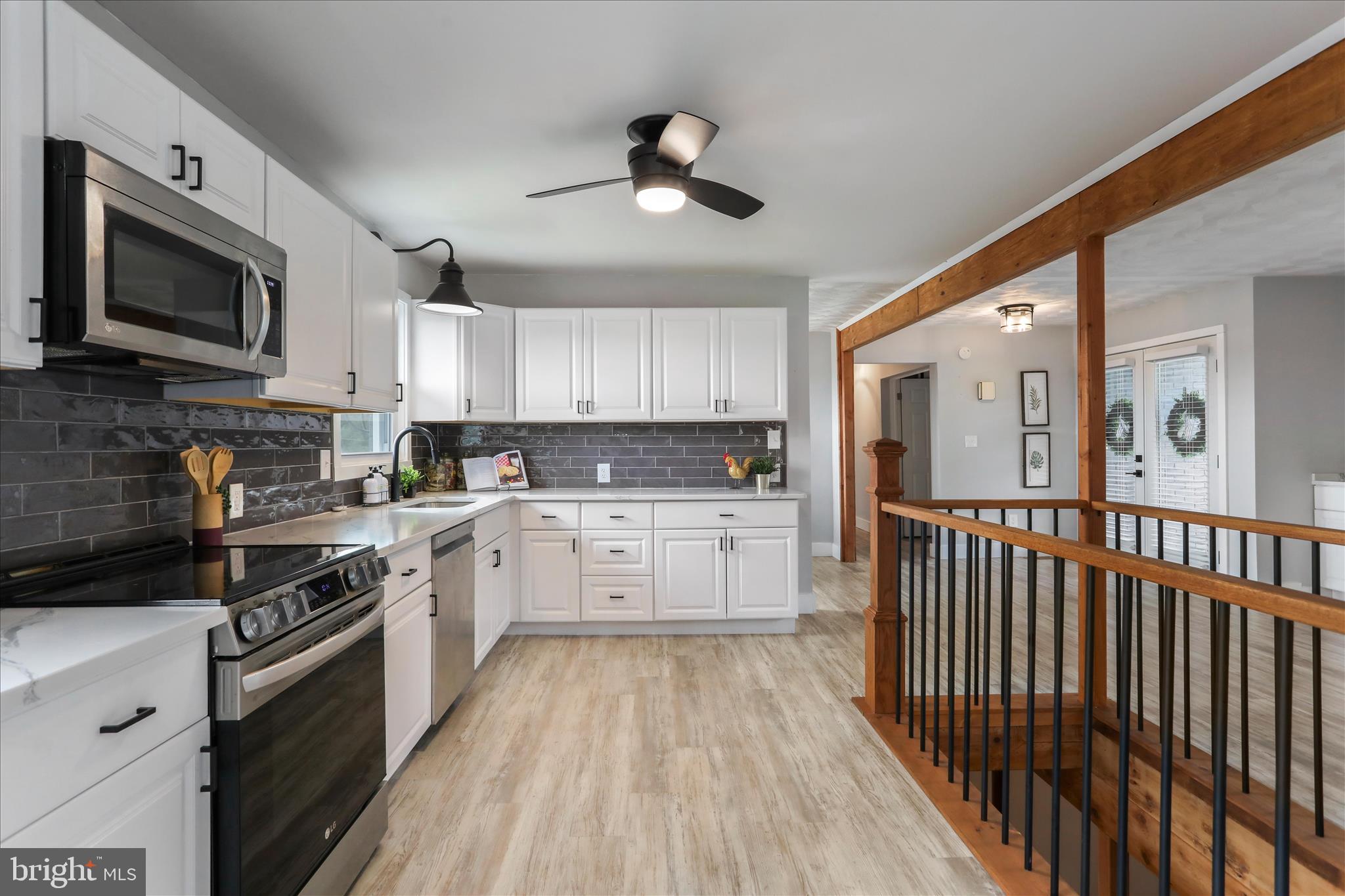 83 Dove Hill Drive Ranson, WV 25438 - Photo 14 of 71 a kitchen with stainless steel appliances granite countertop a stove top oven a sink dishwasher and a refrigerator with wooden floor