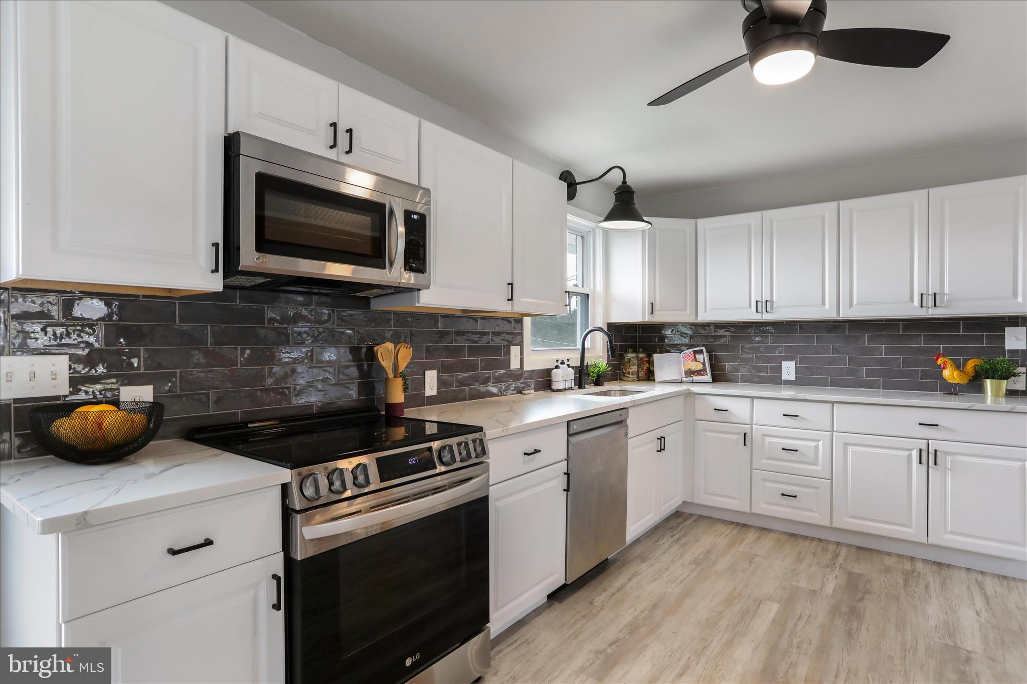 83 Dove Hill Drive Ranson, WV 25438 - Photo 15 of 71 a kitchen with stainless steel appliances a stove a microwave and cabinets