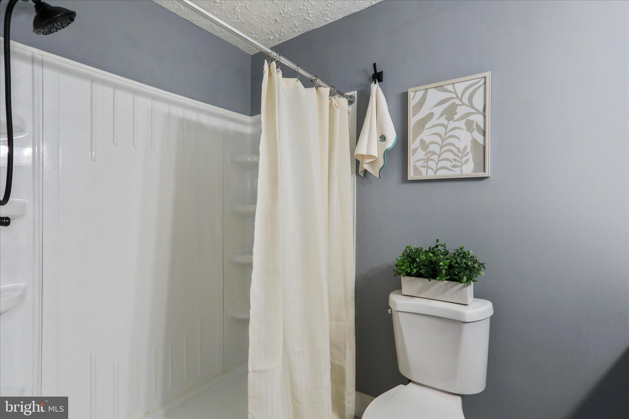 83 Dove Hill Drive Ranson, WV 25438 - Photo 28 of 71 a white toilet sitting next to a shower curtain
