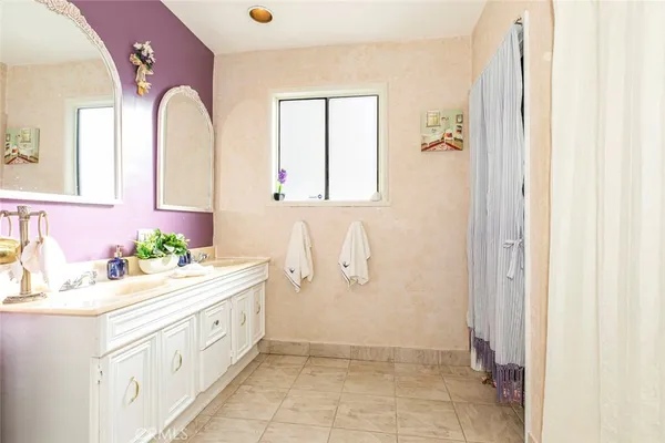 a bathroom with a double vanity sink mirror and a bathtub