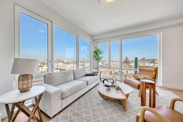 a living room with furniture and floor to ceiling windows
