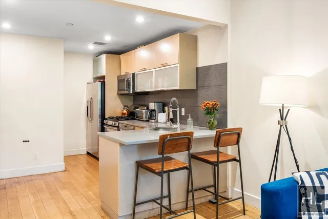 a kitchen with stainless steel appliances granite countertop a sink and a refrigerator