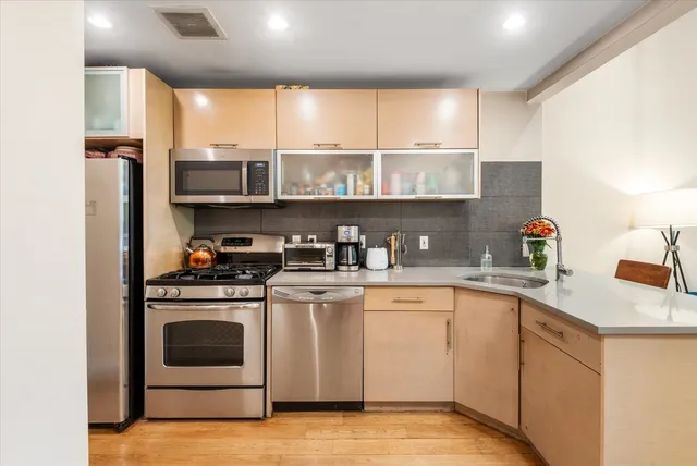 a kitchen with stainless steel appliances granite countertop a sink and a stove