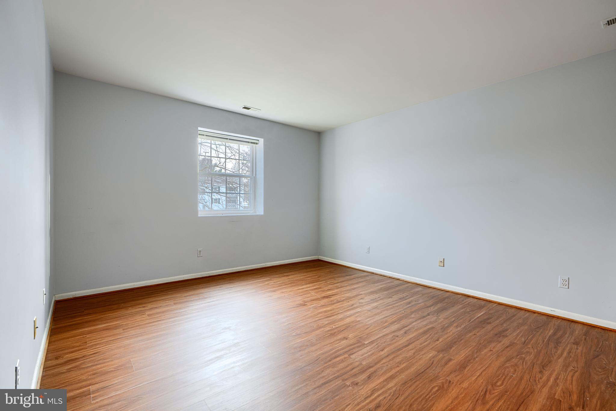 110 Castletown Road, Unit 201 Lutherville-Timonium, MD 21093 - Photo 20 of 41 an empty room with wooden floor and windows