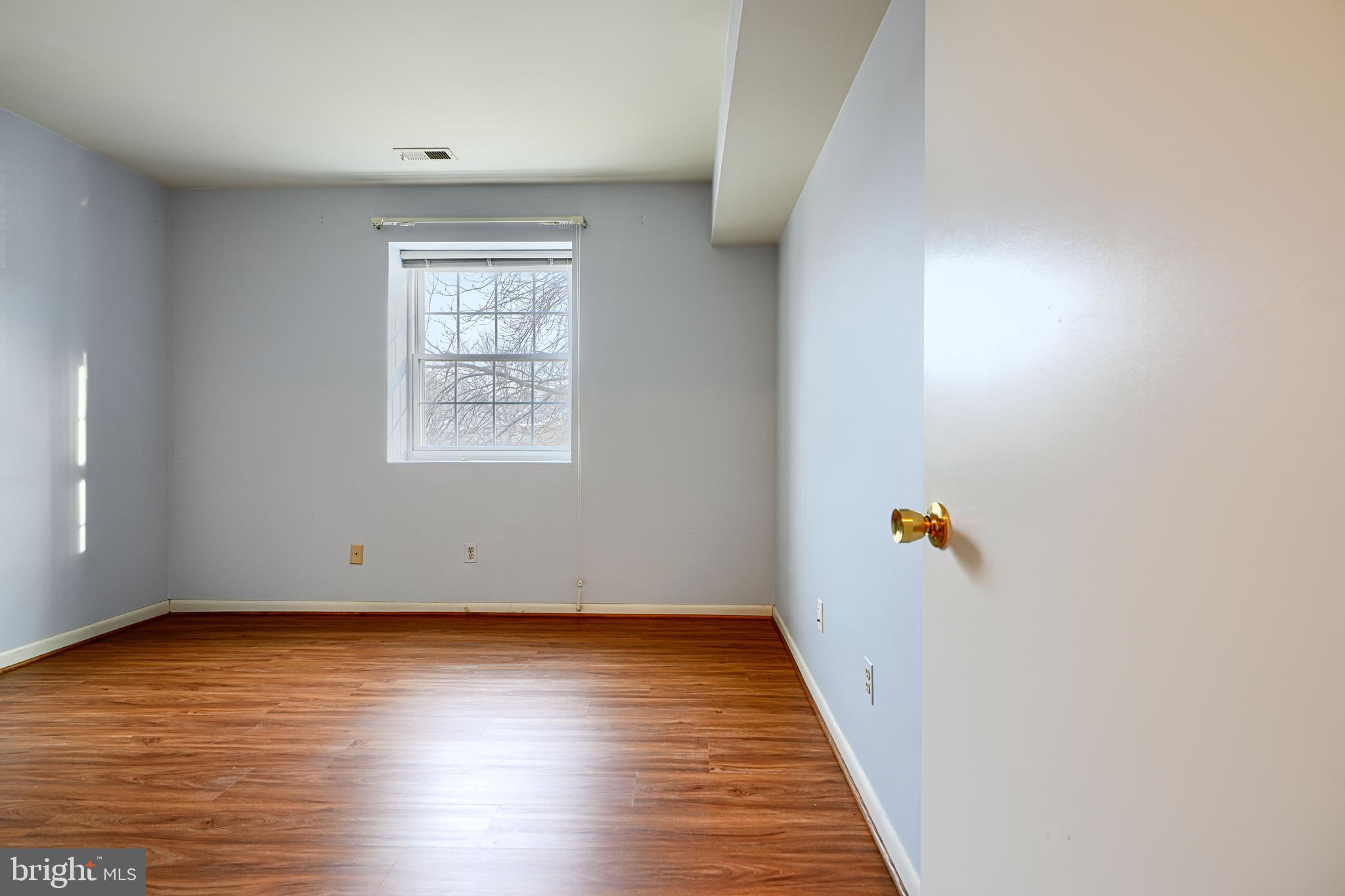 110 Castletown Road, Unit 201 Lutherville-Timonium, MD 21093 - Photo 28 of 41 an empty room with wooden floor and windows