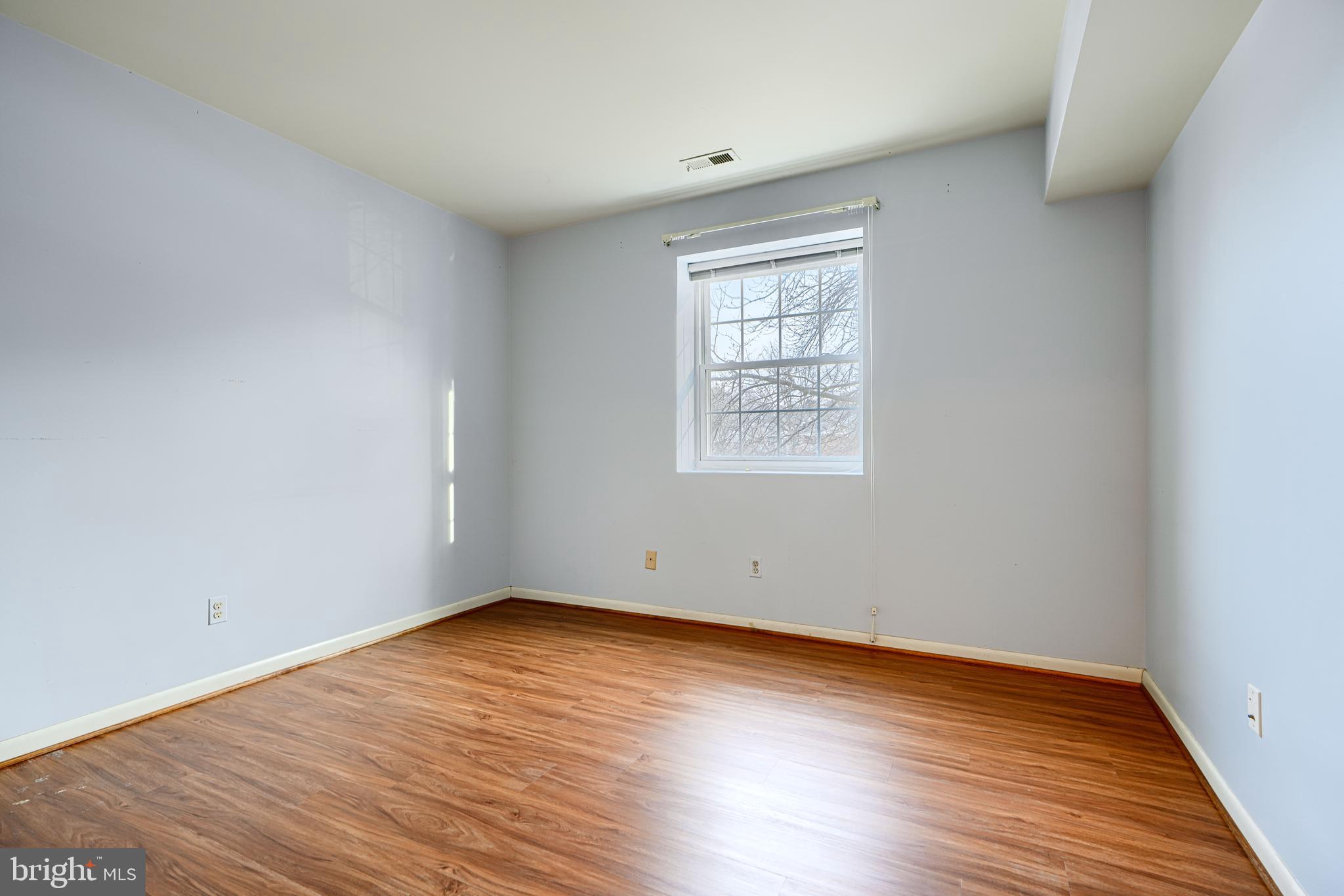 110 Castletown Road, Unit 201 Lutherville-Timonium, MD 21093 - Photo 29 of 41 an empty room with wooden floor and windows