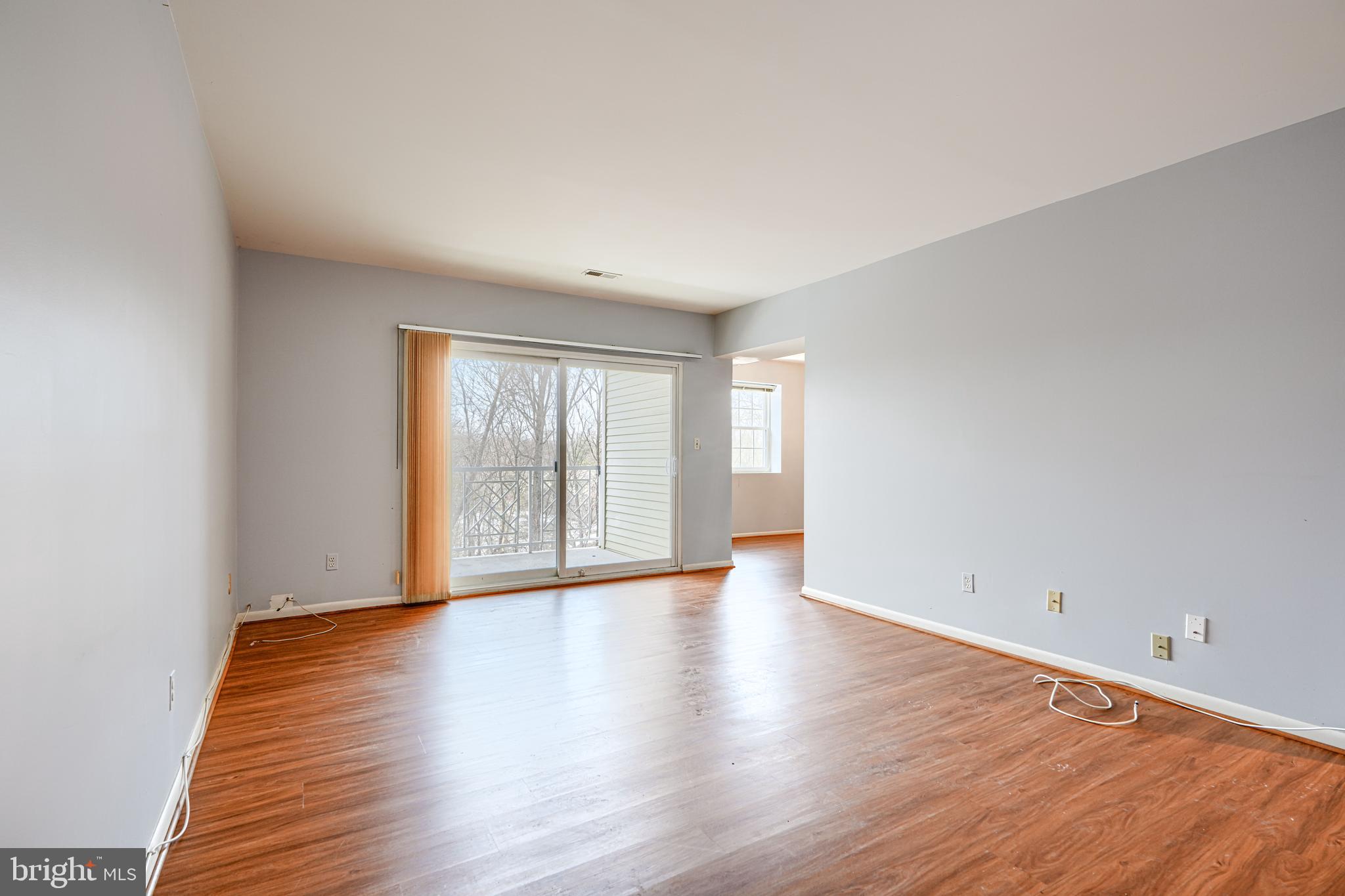110 Castletown Road, Unit 201 Lutherville-Timonium, MD 21093 - Photo 9 of 41 a view of an empty room with wooden floor and glass door