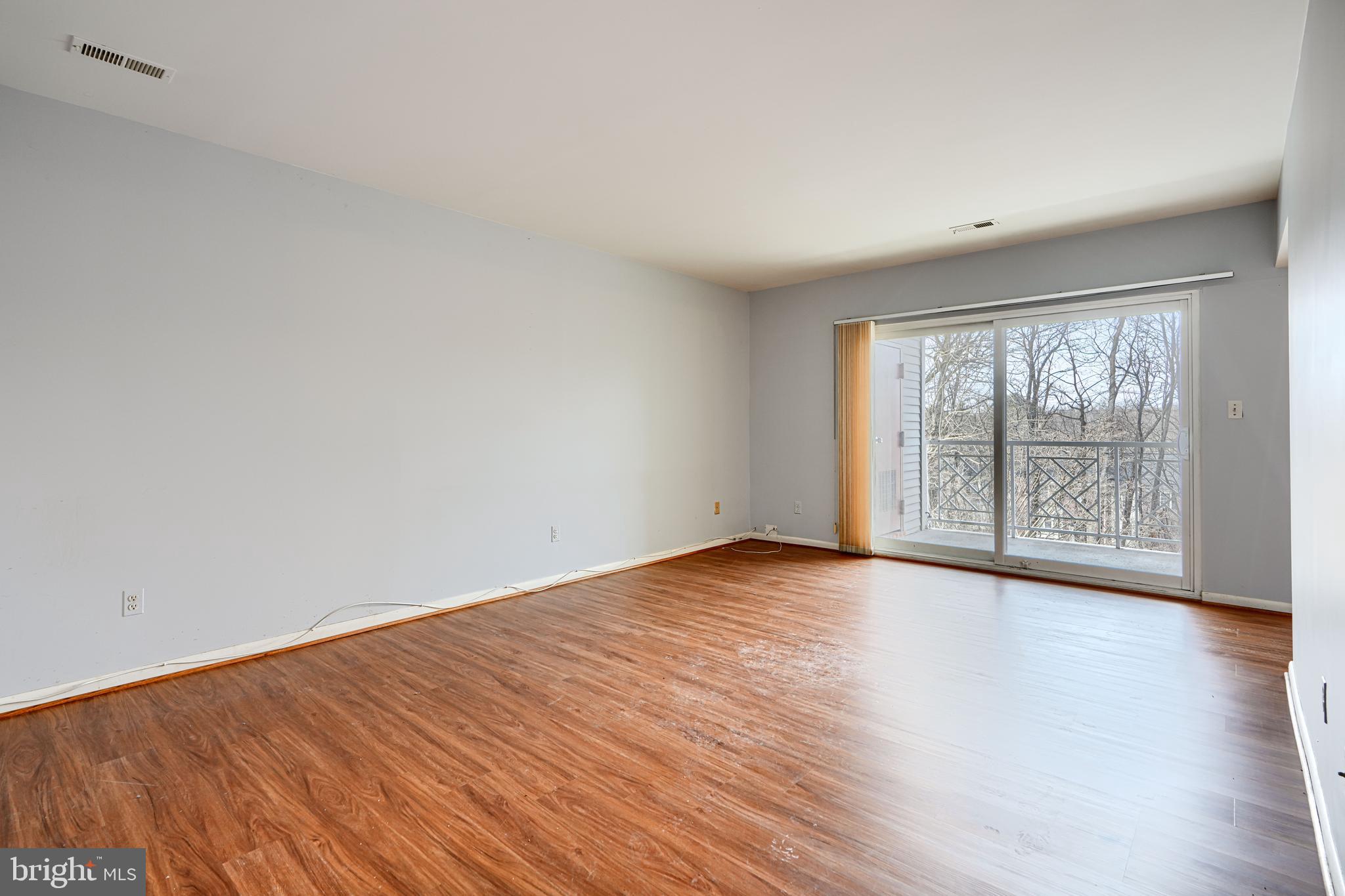 110 Castletown Road, Unit 201 Lutherville-Timonium, MD 21093 - Photo 10 of 41 a view of an empty room with wooden floor and a window