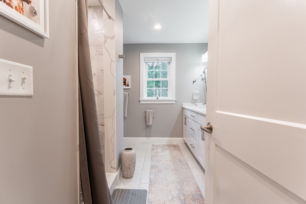 38 Cherry Street, Unit B Hudson, MA 01749 - Photo 23 of 33 a bathroom with a tub and window