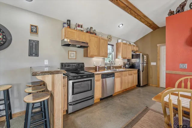 a kitchen with a stove a refrigerator and a dining table