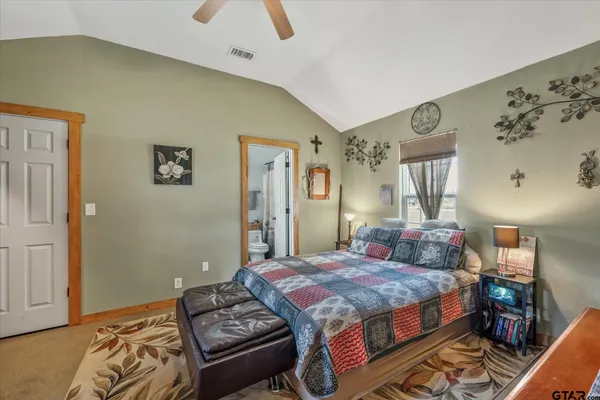 a bedroom with a bed and dresser with mirror