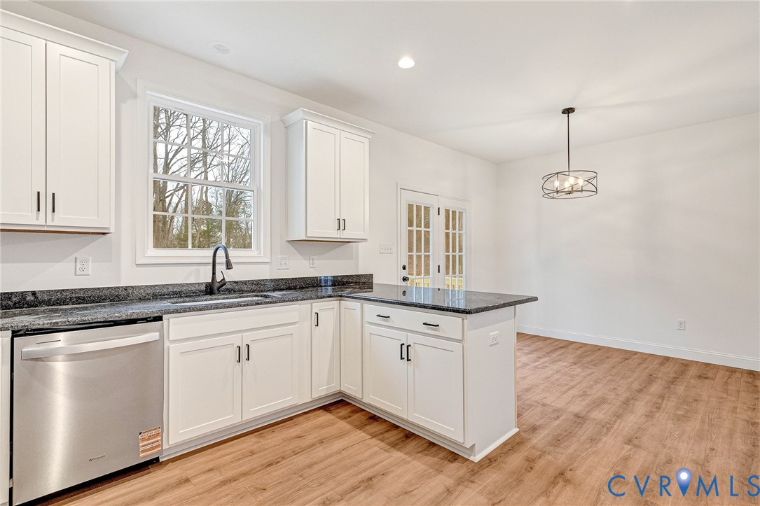 4715 Shannon Hill Road Columbia, VA 23038 - Photo 18 of 52 a kitchen with granite countertop a stove a sink and white cabinets with wooden floor