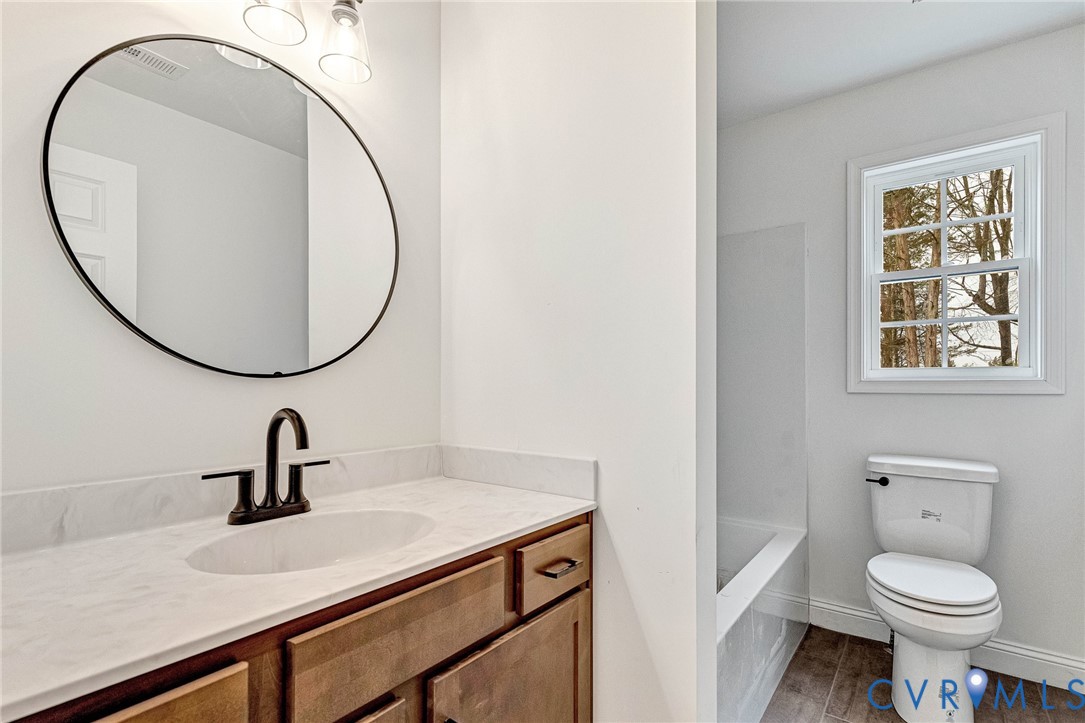 4715 Shannon Hill Road Columbia, VA 23038 - Photo 31 of 52 a bathroom with a toilet a sink and a mirror
