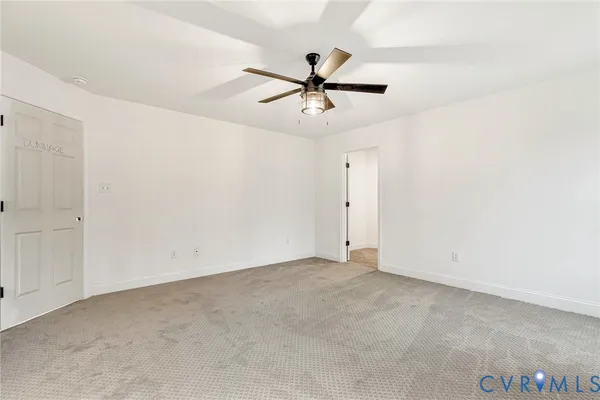 an empty room with a ceiling fan and a window