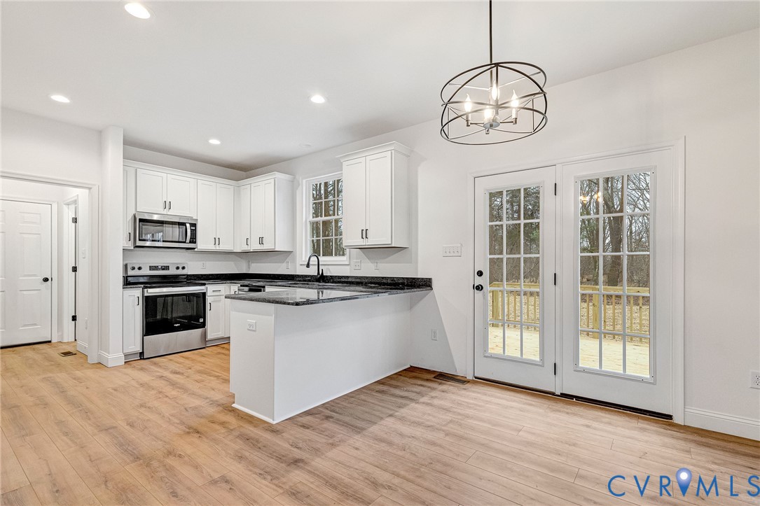 4715 Shannon Hill Road Columbia, VA 23038 - Photo 6 of 52 a kitchen with stainless steel appliances granite countertop a stove a sink dishwasher a refrigerator and white cabinets with wooden floor