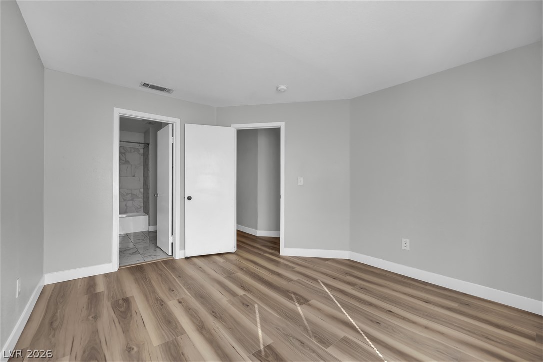 698 South Racetrack Road, Unit 1521 Henderson, NV 89015 - Photo 18 of 33 Step into a generously proportioned bedroom featuring wood flooring and a refreshing neutral palette.
