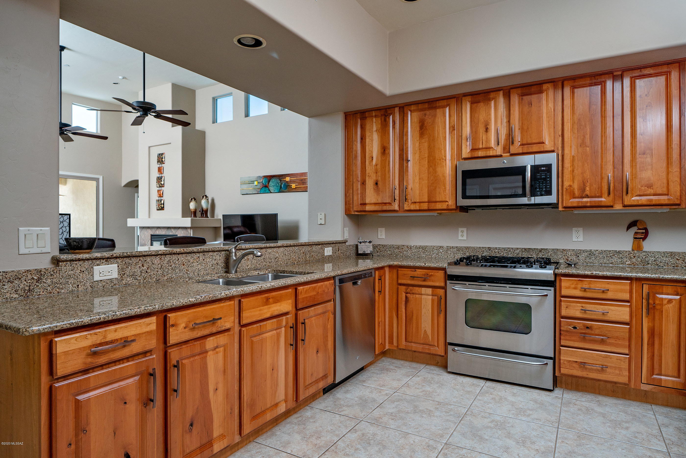 4440 West Crystal Ranch Place Marana, AZ 85658 - Photo 13 of 28 a kitchen with stainless steel appliances granite countertop a stove microwave and cabinets