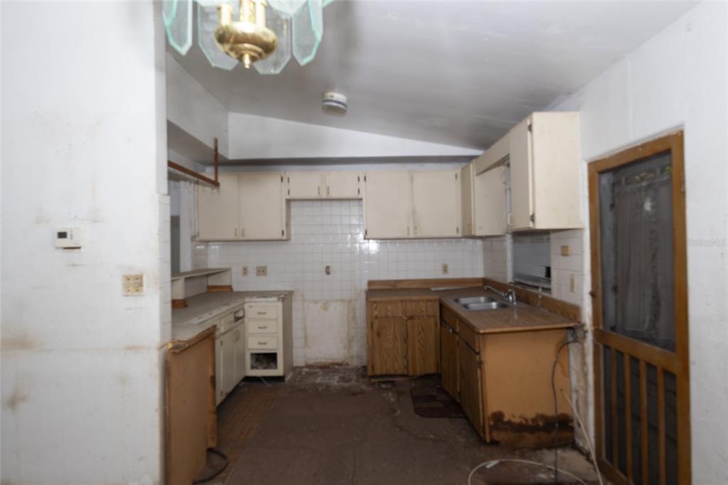 4711 Rio Grande Avenue Orlando, FL 32839 - Photo 31 of 38 a kitchen with stainless steel appliances granite countertop a sink a stove and a refrigerator