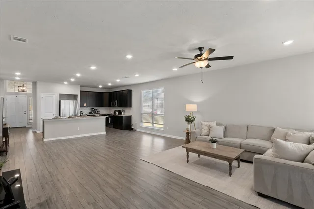 a kitchen with stainless steel appliances kitchen island granite countertop a sink stove and refrigerator