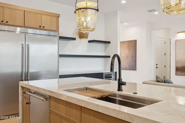 a kitchen with stainless steel appliances granite countertop a sink and a refrigerator
