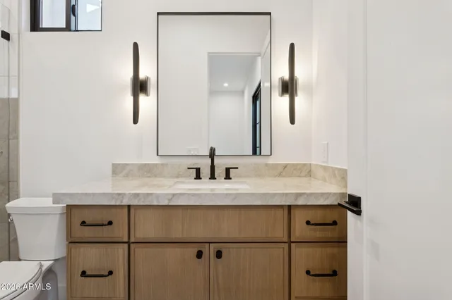 a bathroom with a granite countertop sink and a mirror