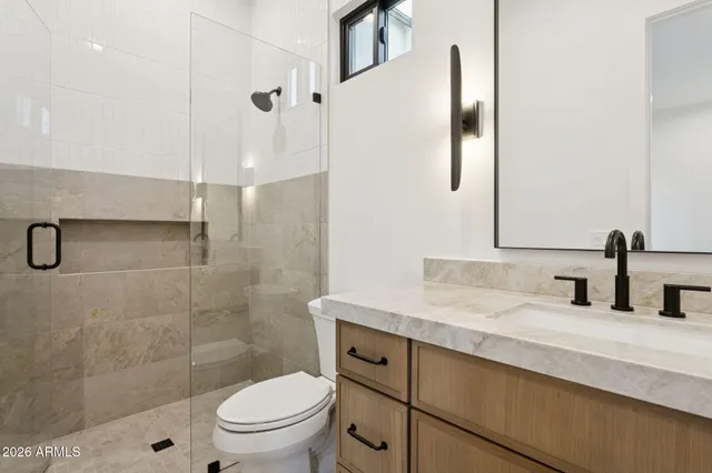 a bathroom with a granite countertop sink toilet and shower
