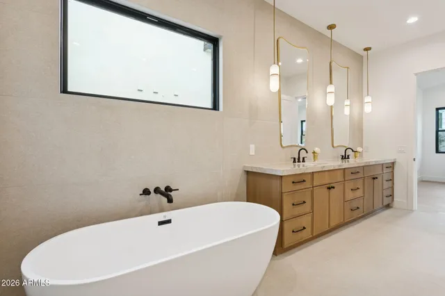 a bathroom with a double vanity sink mirror and bathtub