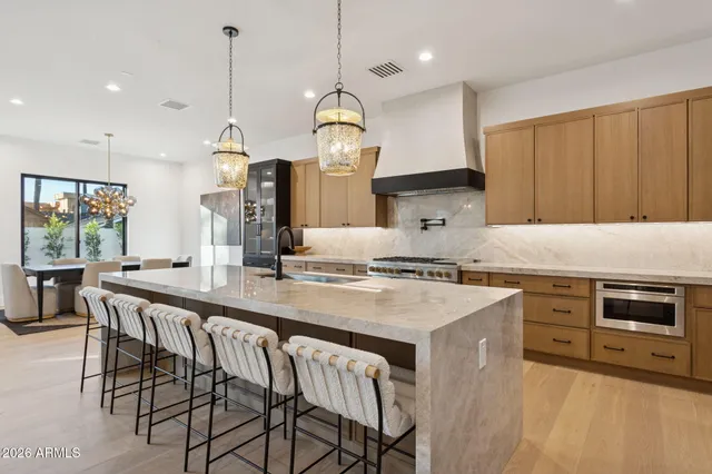 a kitchen with stainless steel appliances granite countertop a stove a sink and a refrigerator