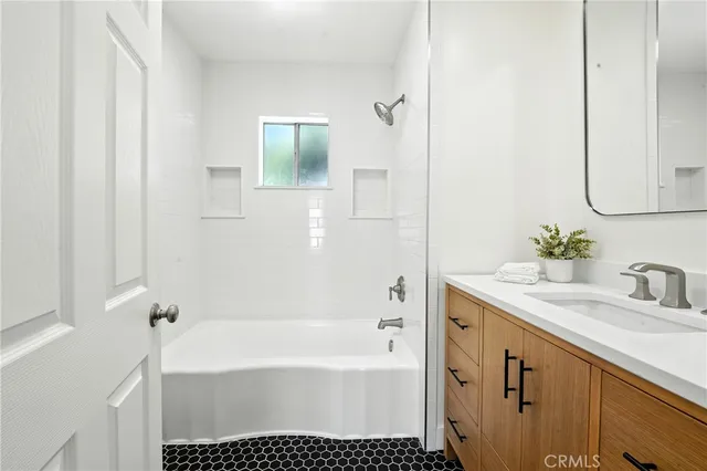 a bathroom with a tub sink and a mirror