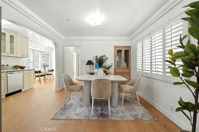 a dining room with wooden floor and large windows