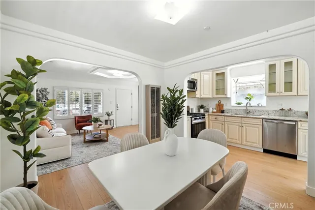 a large white kitchen with cabinets a sink a stove and a dining table