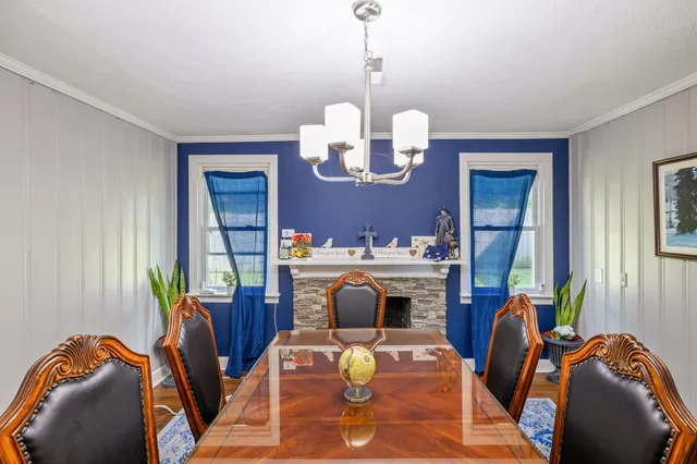 a living room with furniture chandelier and a mirror