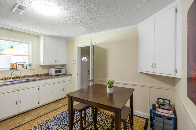 a kitchen with granite countertop a sink cabinets and dining table