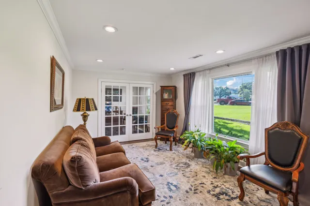 a living room with furniture a bookshelf and a window
