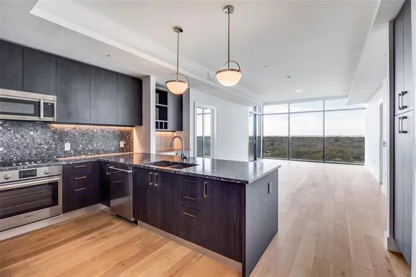 a kitchen with kitchen island granite countertop a sink stainless steel appliances and cabinets